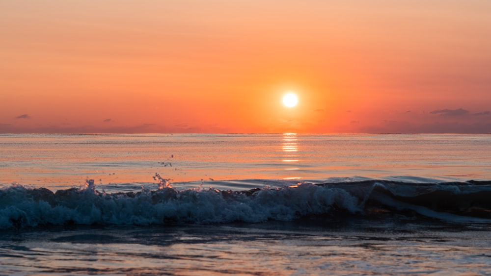 Le soleil se couche sur les vagues de l’océan