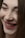 A close-up of a person's face focusing on their smile with closed eyes. The expression suggests happiness and contentment, and the makeup is subtle yet accentuates the features like lips and eyebrows.