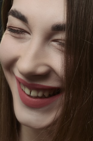 A close-up of a smiling customer receiving a beauty treatment.