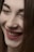 A close-up of a person's face focusing on their smile with closed eyes. The expression suggests happiness and contentment, and the makeup is subtle yet accentuates the features like lips and eyebrows.