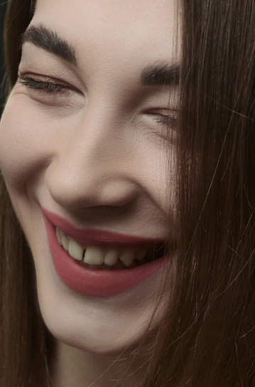 A close-up of a client’s radiant smile after a fresh makeover at éclat belle.