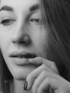 A close-up portrait of a woman with soft natural lighting highlighting her thoughtful expression.