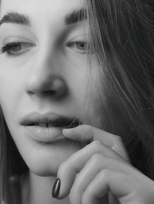 Close-up of a woman with soft natural light highlighting her thoughtful expression.
