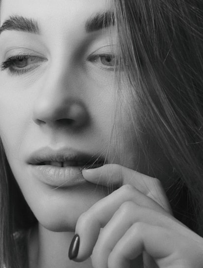 Close-up portrait of a woman with natural light highlighting her thoughtful expression.