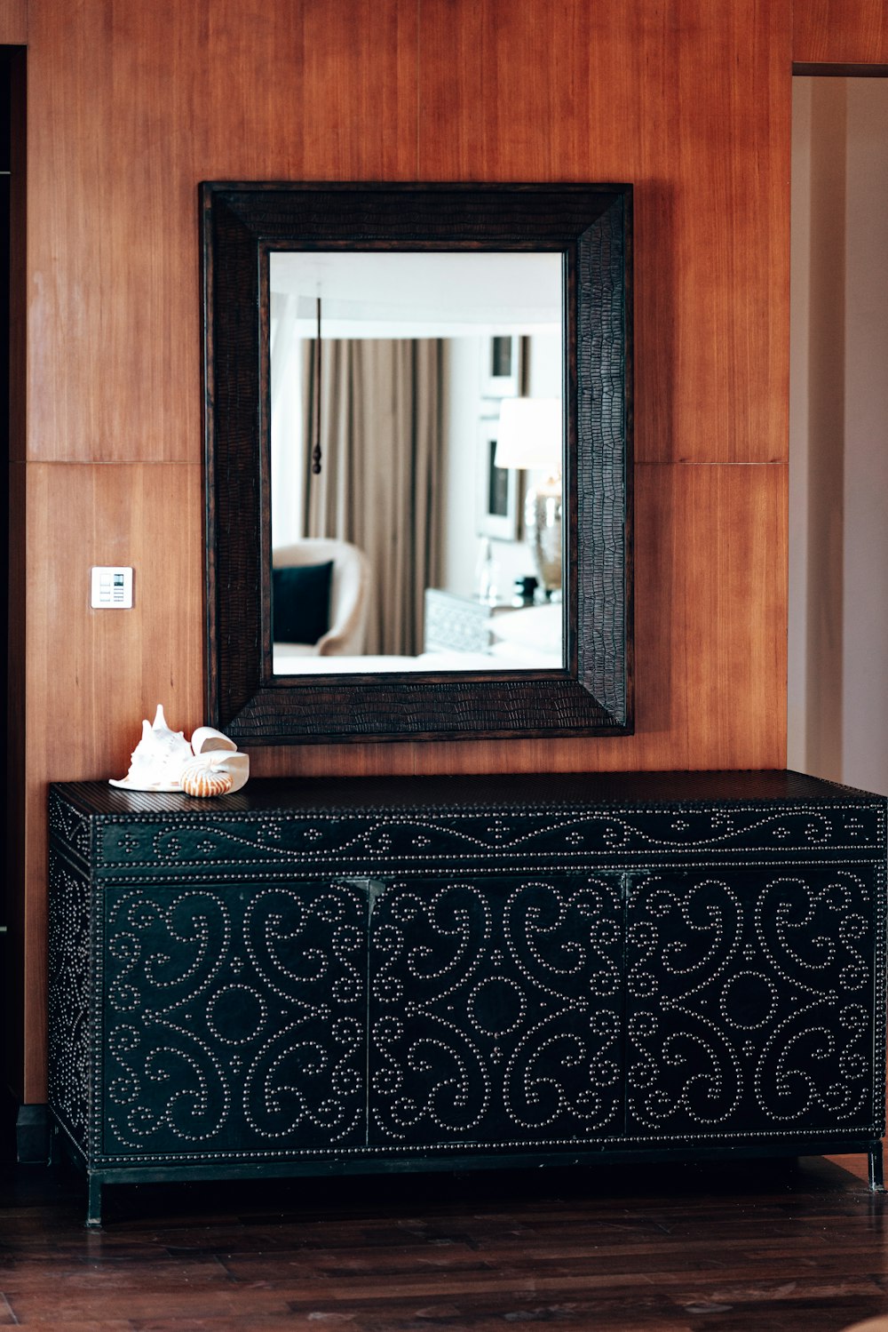 a mirror is hanging on the wall above a black cabinet