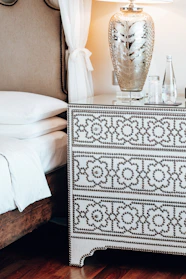 A serene bedroom scene with a king-size bed, nightstands, and a dresser in soft, inviting tones.