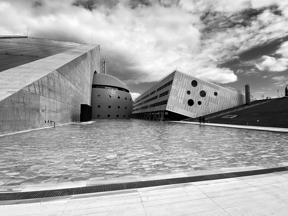 a black and white photo of a building and a pool