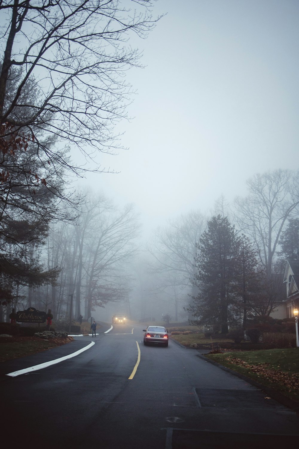 a car driving down a road in the fog