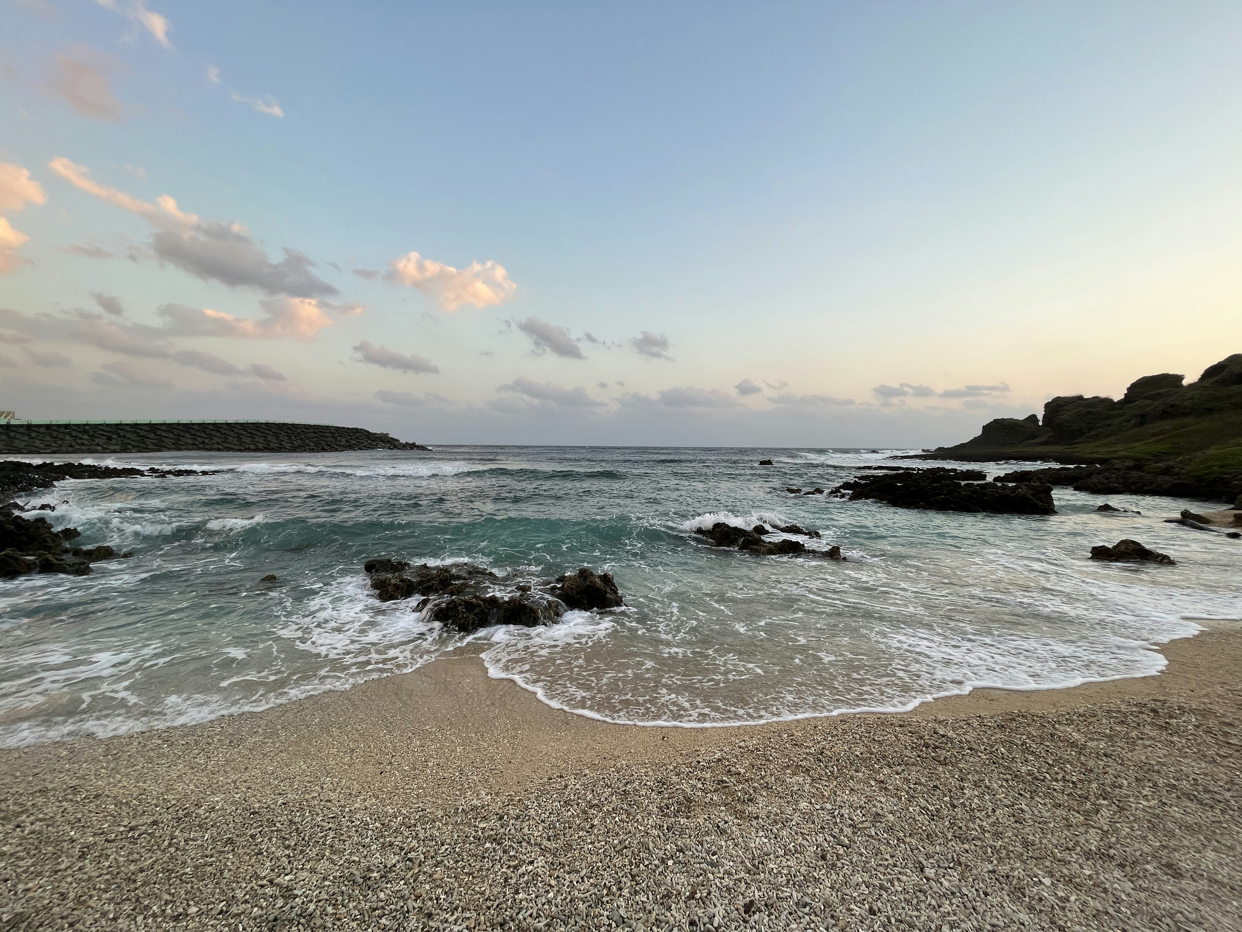 a sandy beach with waves coming in to shore