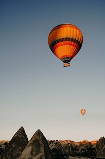 A vibrant hot air balloon floating over the fairy chimneys of Cappadocia at sunrise.