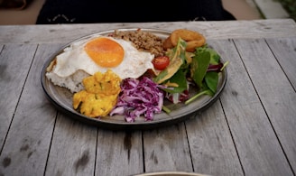 Close-up of a vibrant plate featuring khichuri with crispy fried eggplant and a dollop of yogurt.