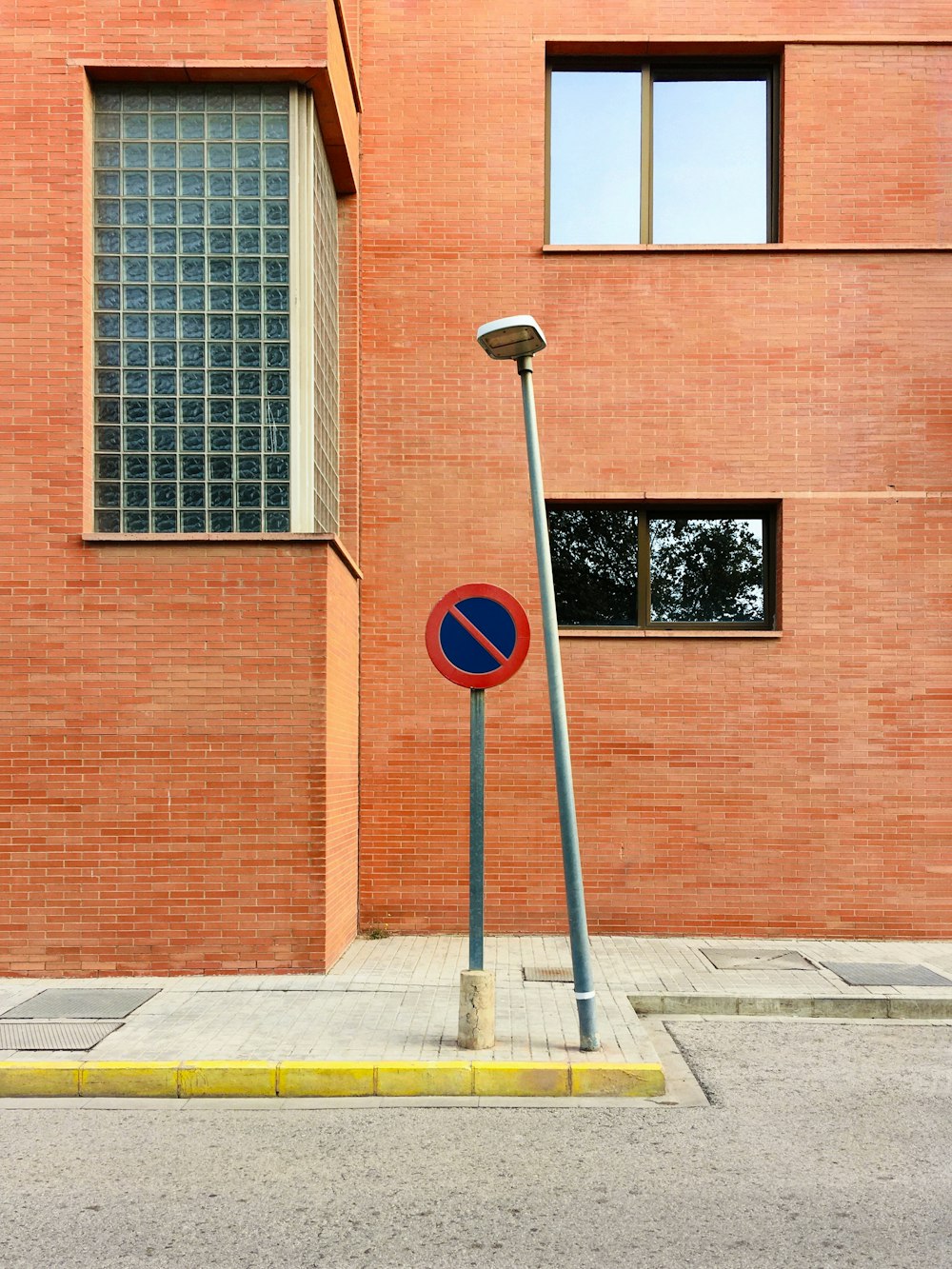 a no parking sign in front of a brick building