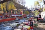 a group of people sitting at a table next to a river