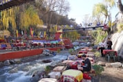 a group of people sitting at a table next to a river