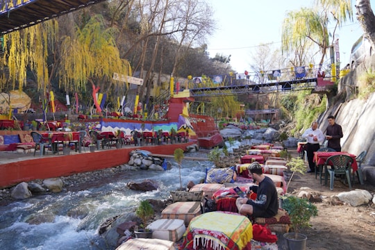 a group of people sitting at a table next to a river