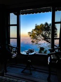 A serene mountain landscape view from the hotel’s large panoramic window at sunset.