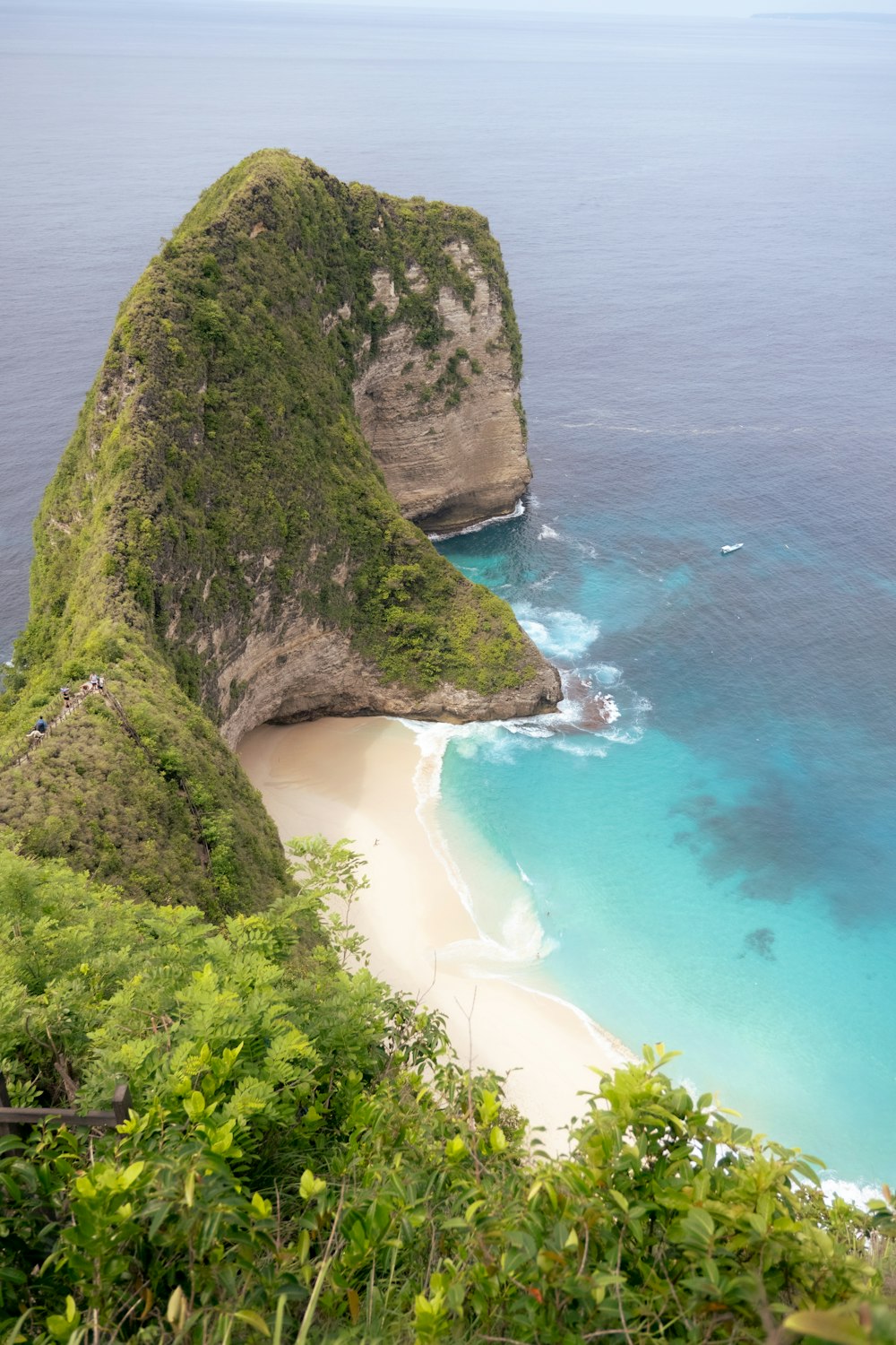 a beach with a large rock sticking out of the water