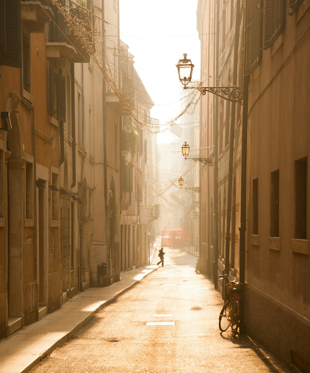 a person walking down a street next to tall buildings