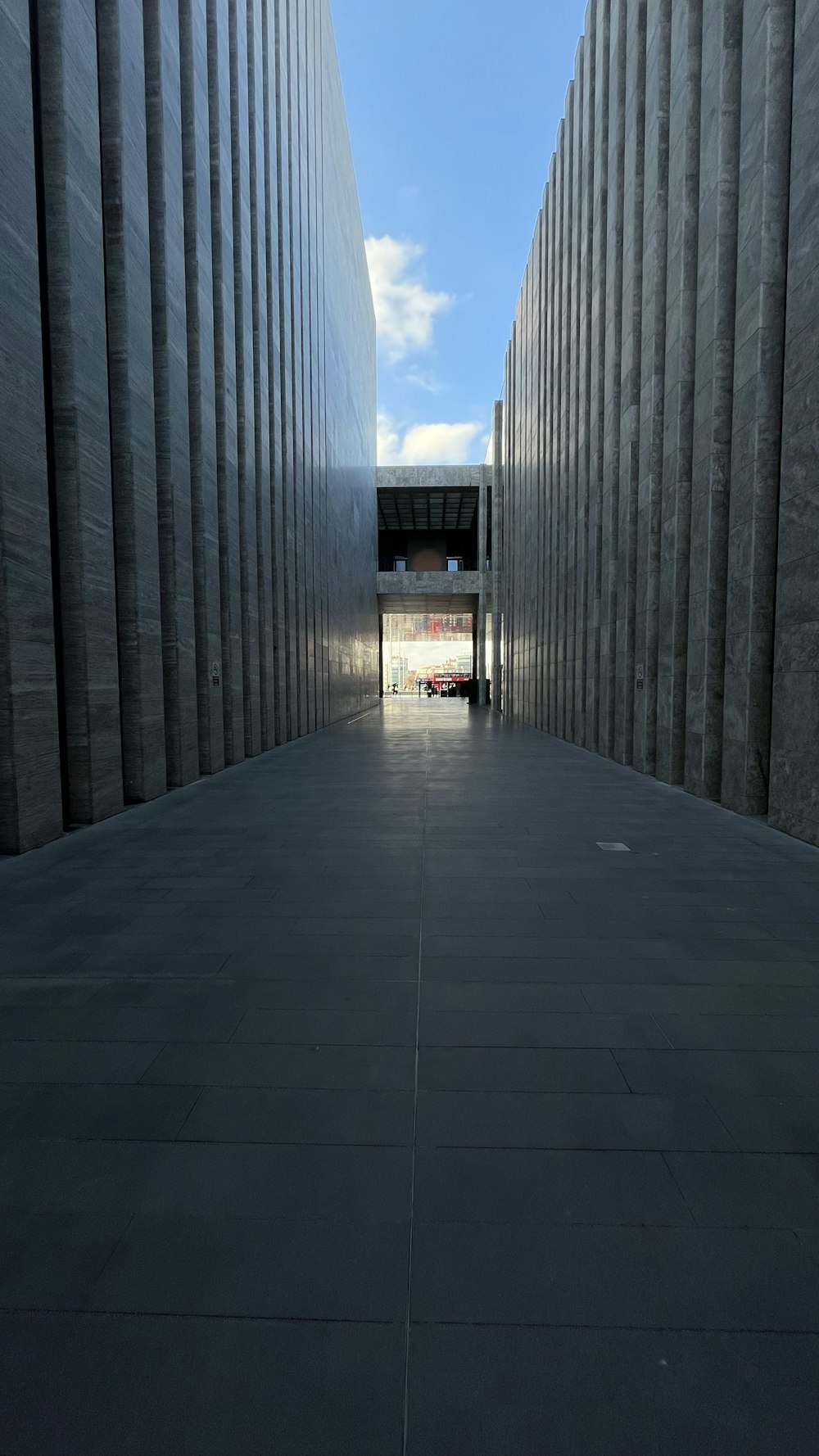 a walkway between two buildings with a sky background