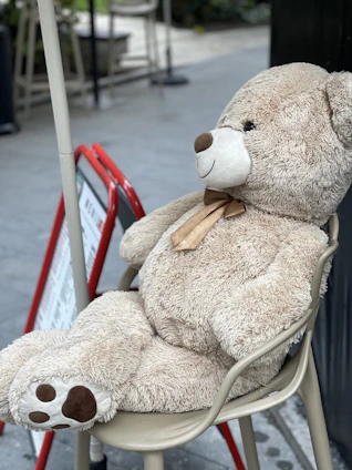 Brightly colored plush teddy bear sitting on a cozy chair