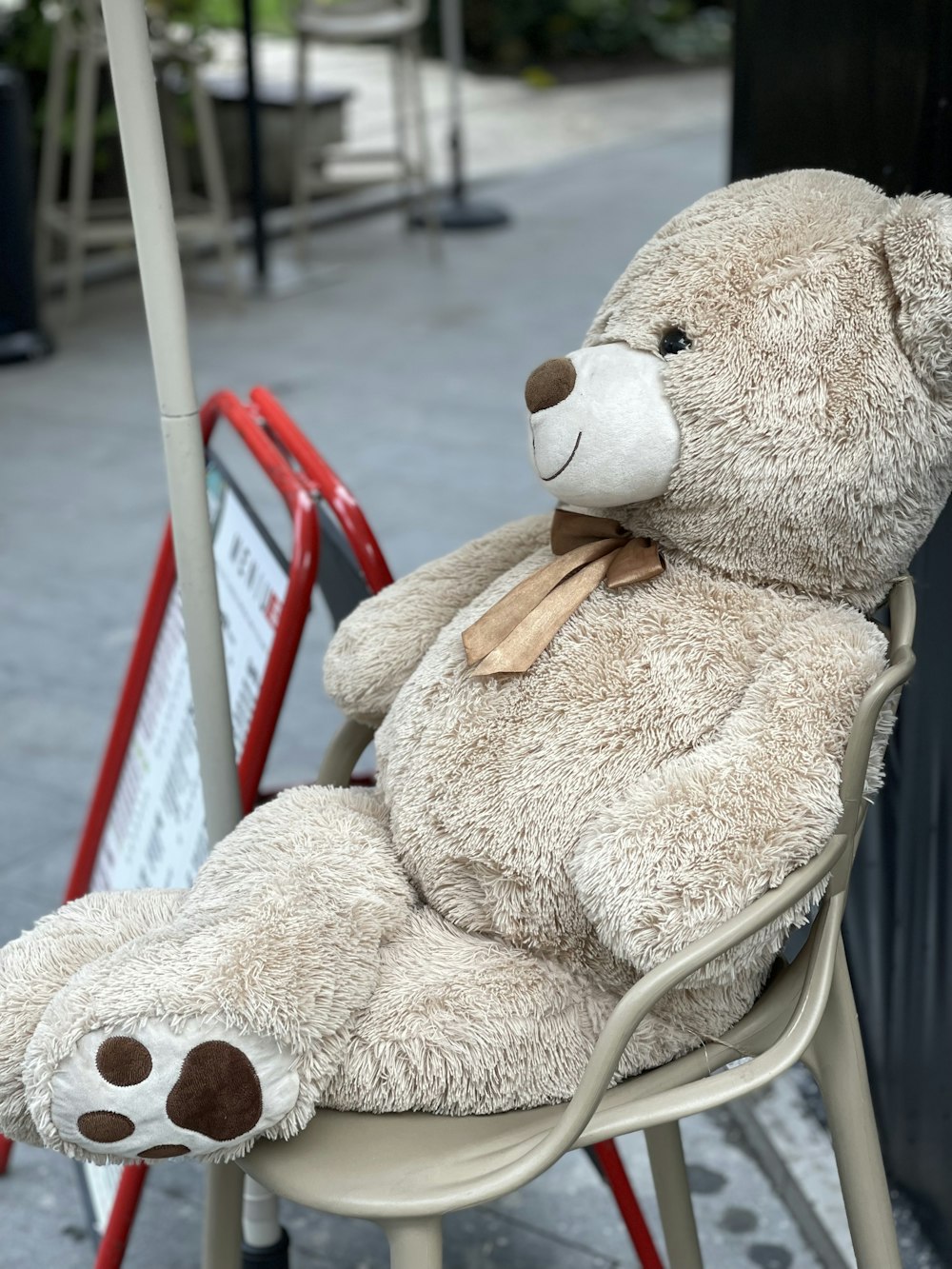 a brown teddy bear sitting on a chair