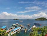 Colorful traditional boats docked at a peaceful Langkawi beach under clear blue skies.