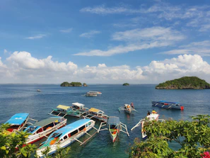 Colorful traditional boats docked at a peaceful Langkawi beach under clear blue skies.
