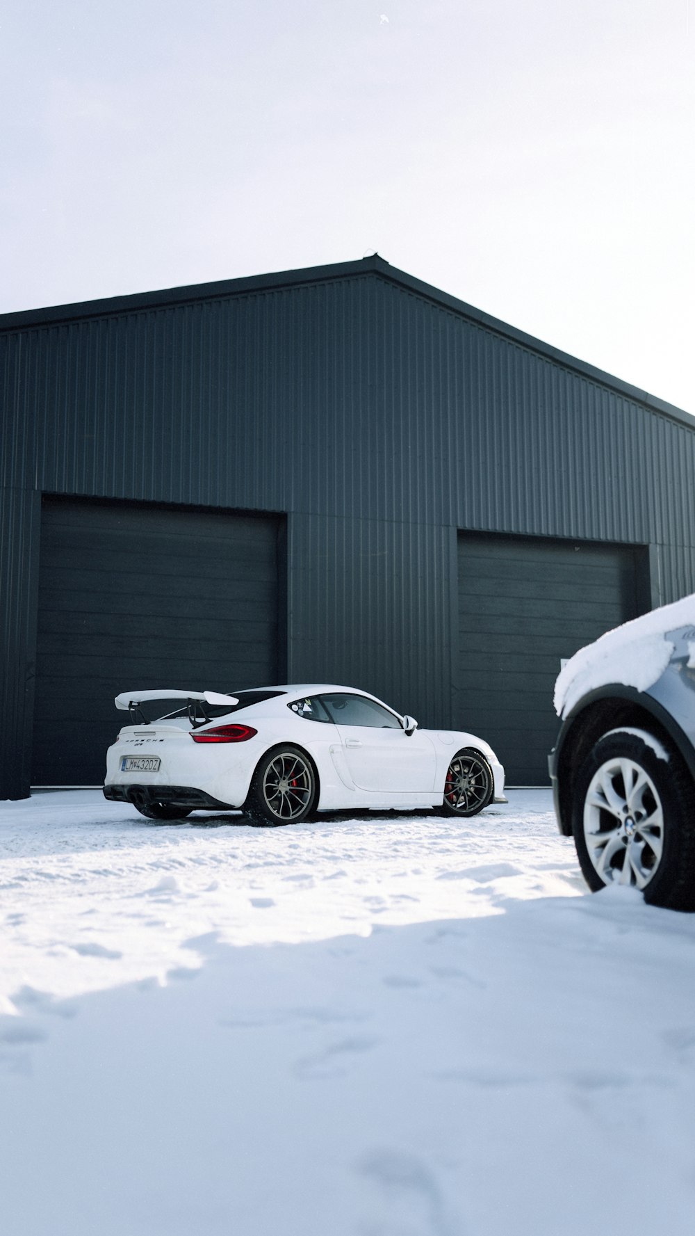 two cars parked in front of a building in the snow