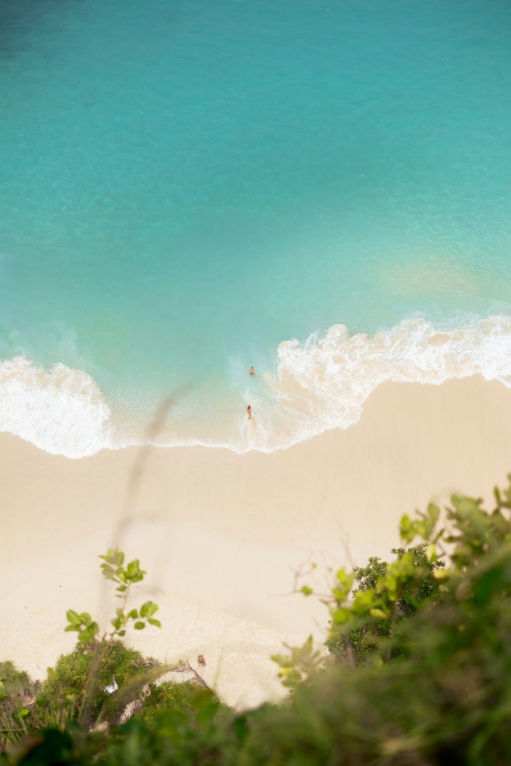 Una vista de una playa desde arriba mirando hacia abajo en el agua