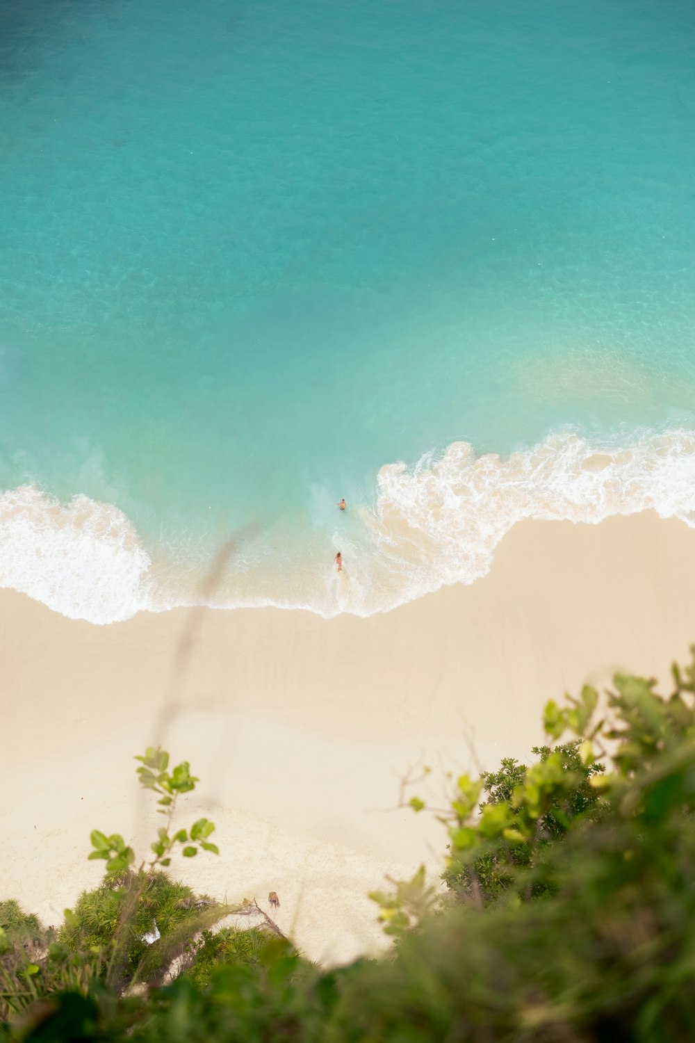 una vista di una spiaggia dall'alto che guarda giù verso l'acqua