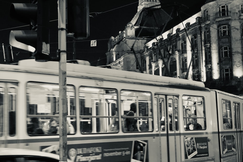 a black and white photo of a trolley on a city street