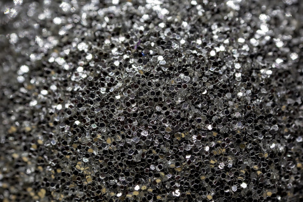 a close up of a black and silver glitter background