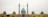 A large mosque with a central blue dome and multiple smaller domes on each side. Two tall minarets flank the central structure, adorned with intricate patterns. The architecture features a combination of yellow and turquoise tiles, showcasing detailed craftsmanship.