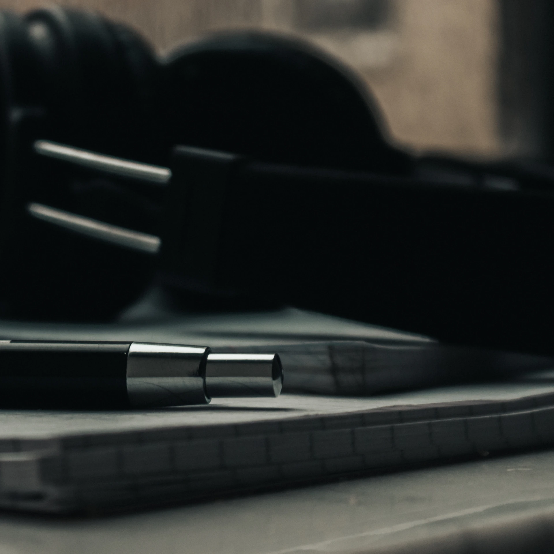 a pen sitting on top of a notebook next to a pair of headphones