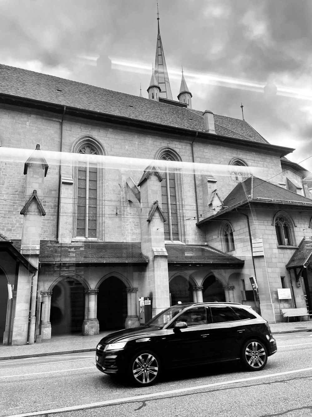 a black car parked in front of a church