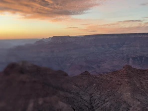 A vibrant sunset over the cliffs of Barrancas del Cobre with travelers enjoying the view.