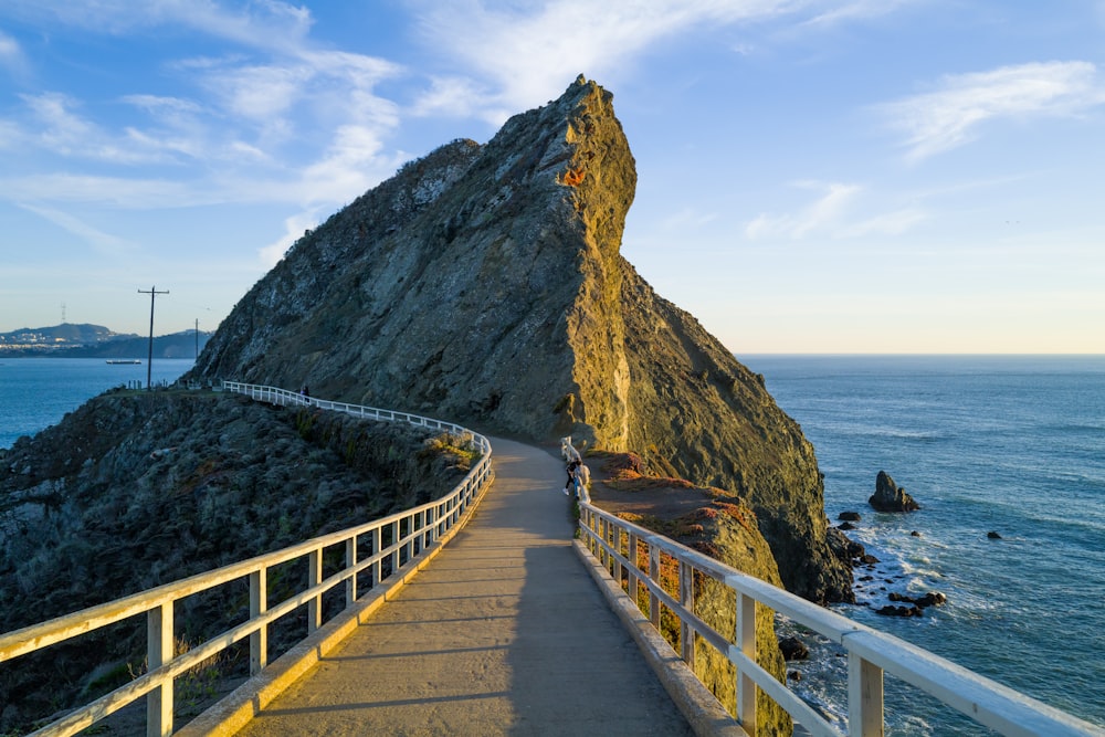 a walkway leading to the top of a mountain next to the ocean