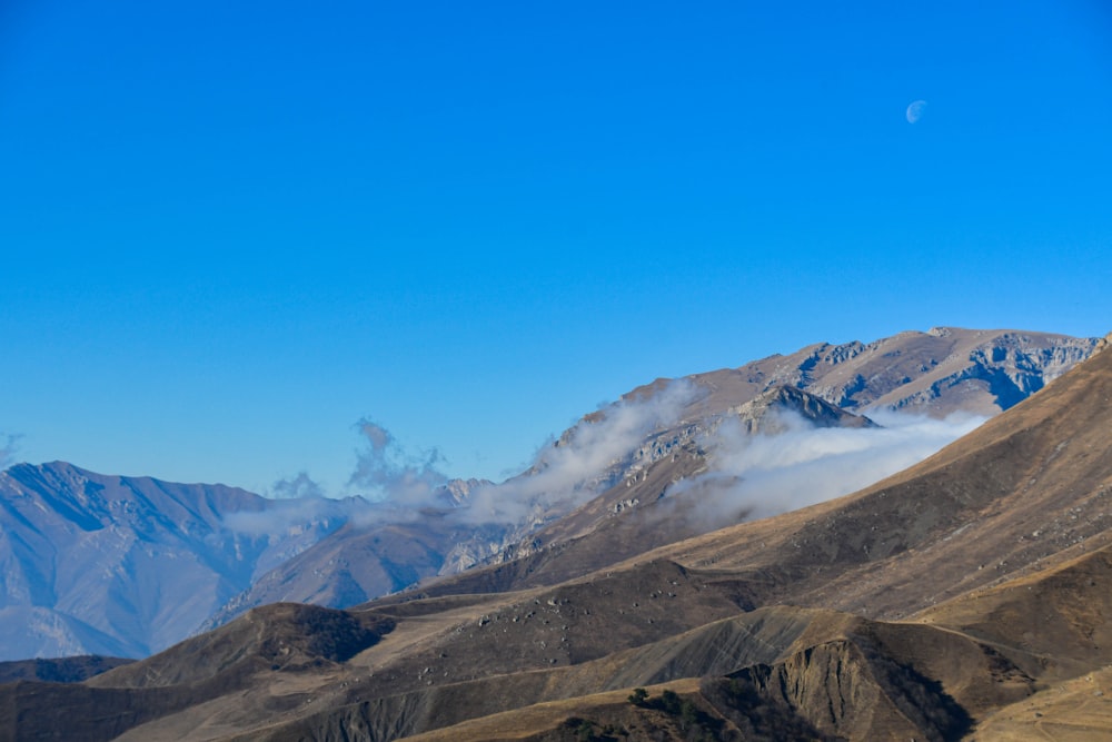 a view of a mountain range with low clouds