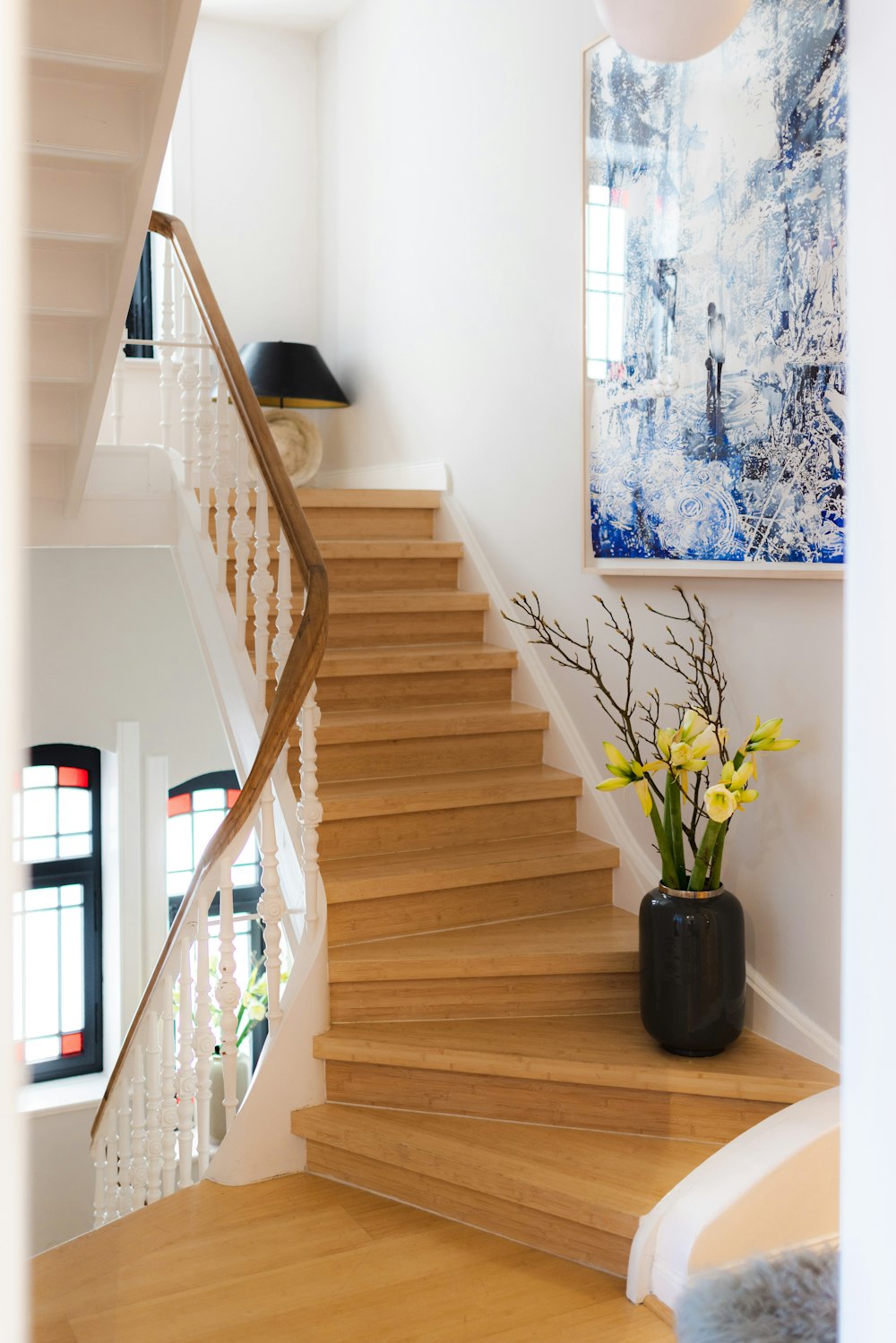 a vase of flowers sitting on a wooden staircase