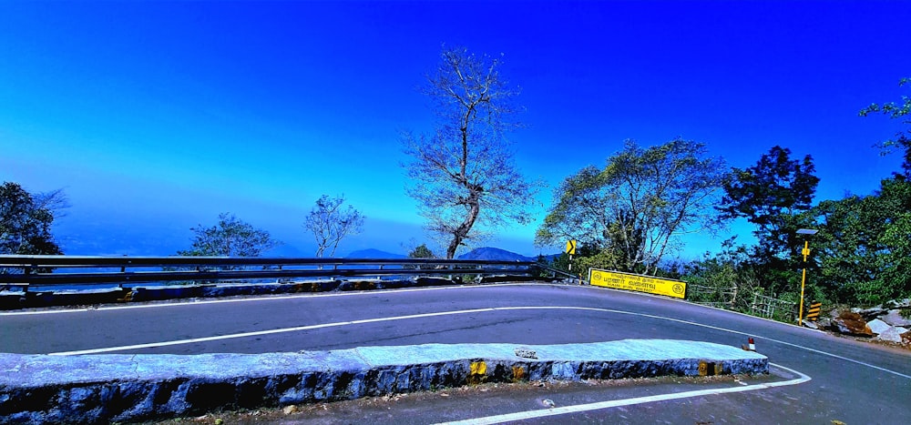 uma estrada curva com um sinal ao lado dela