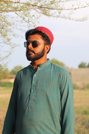 A customer wearing a soft beige kapor kurta, smiling in a sunlit garden.