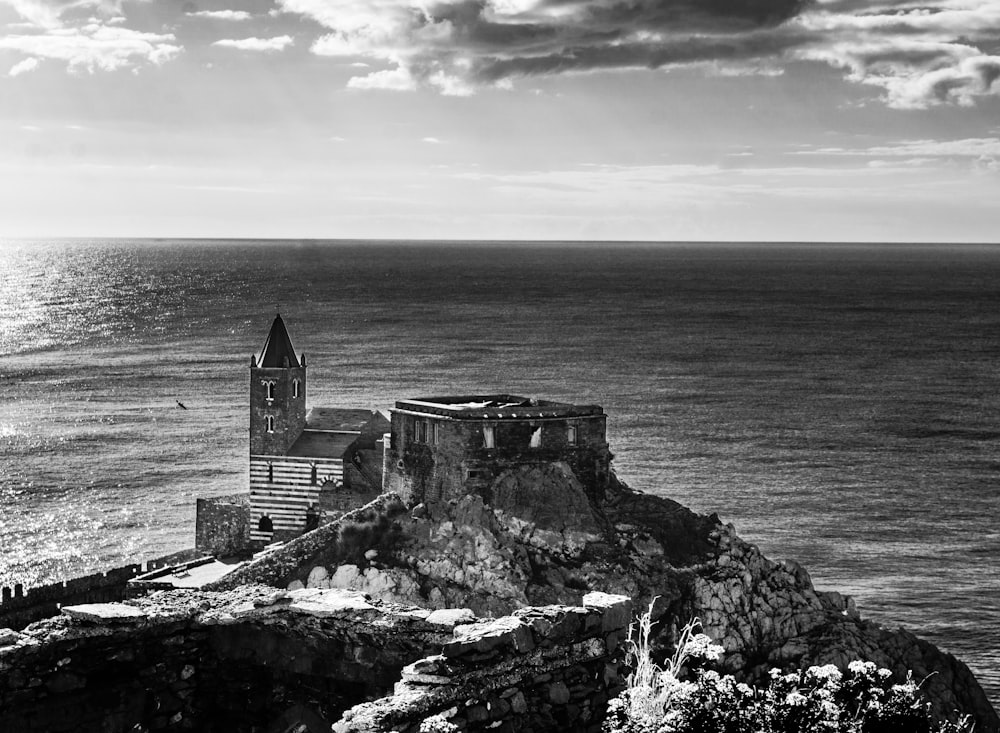 Una foto en blanco y negro de un castillo en un acantilado