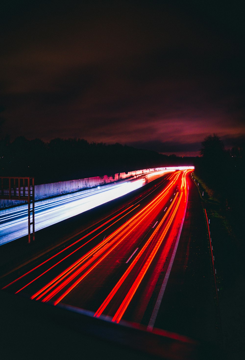 a long exposure photo of a highway at night