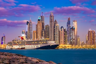 a large cruise ship in front of a city skyline