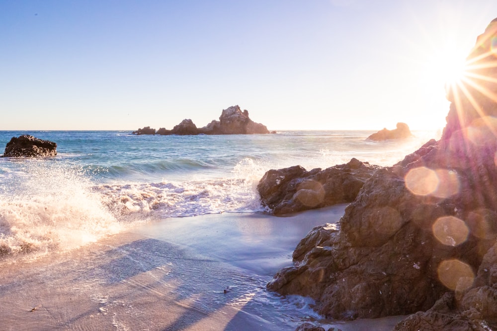 Il sole splende luminoso su una spiaggia rocciosa