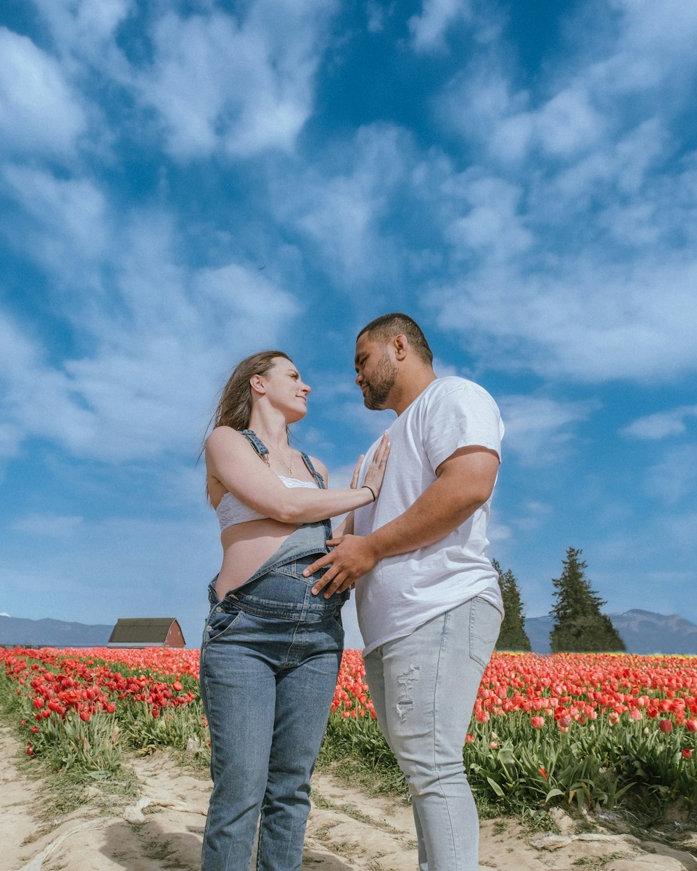 a man and a woman standing in a field of flowers