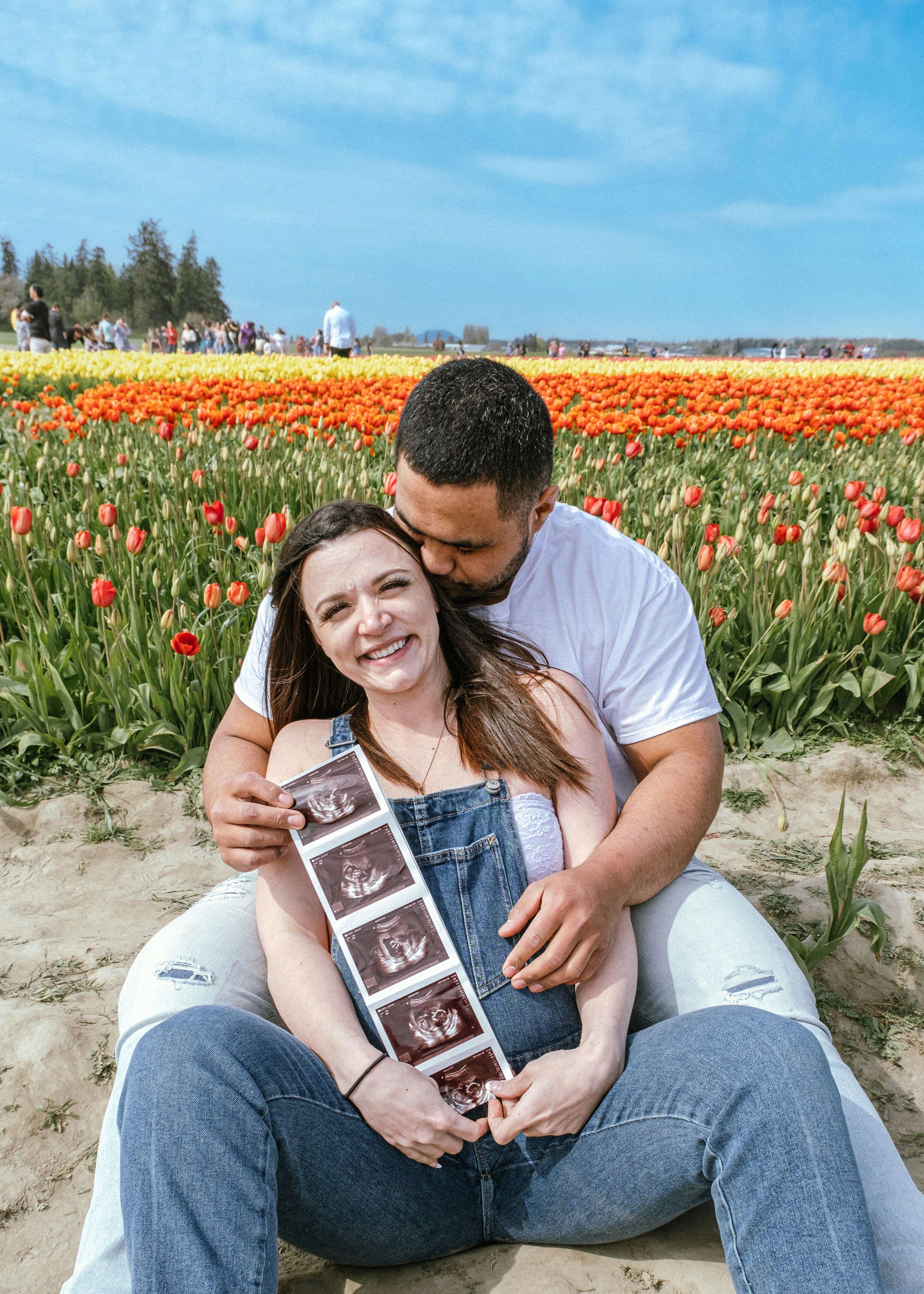 a man and a woman sitting in a field of flowers