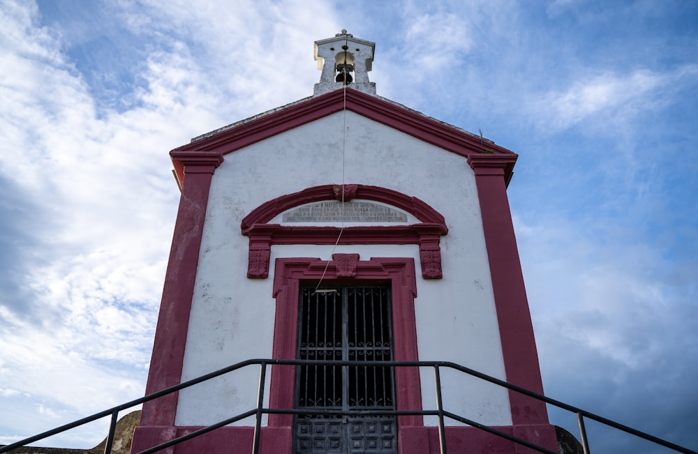 a red and white building with a bell tower