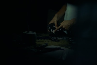Hands of players holding cards during an intense poker game in a digital environment.