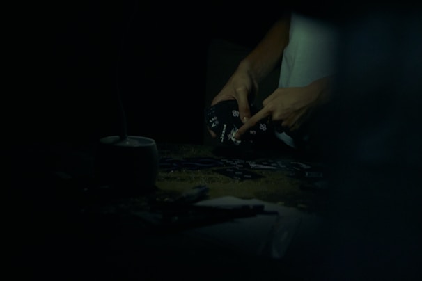 Close-up of hands playing a card game on a table.